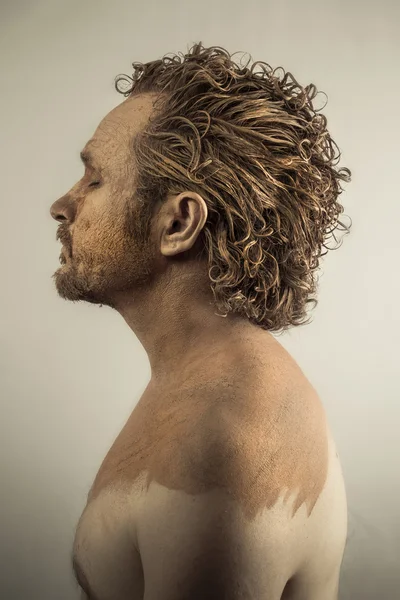 Sognando, uomo coperto di fango, nudo, di profilo, pelle sporca — Foto Stock