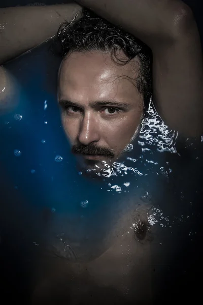 Sexy man diep in blauw water — Stockfoto