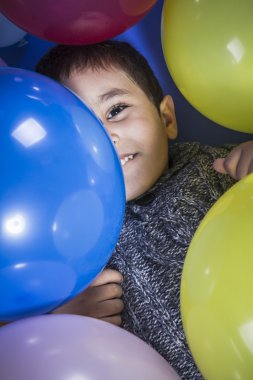 tatlı, çocuk bir partide balonlar çevrili