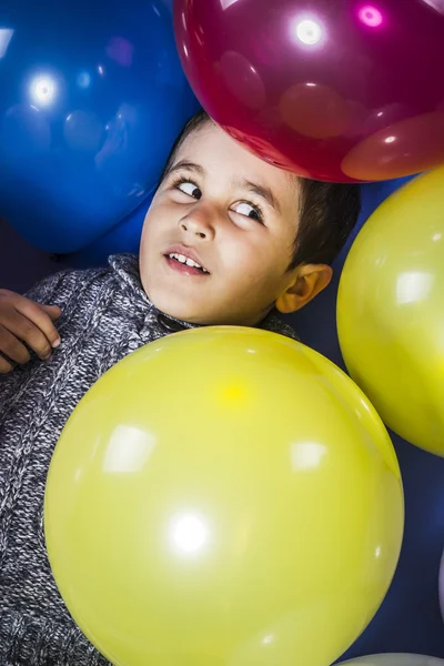 Child surrounded by balloons at a party — Stock Photo, Image