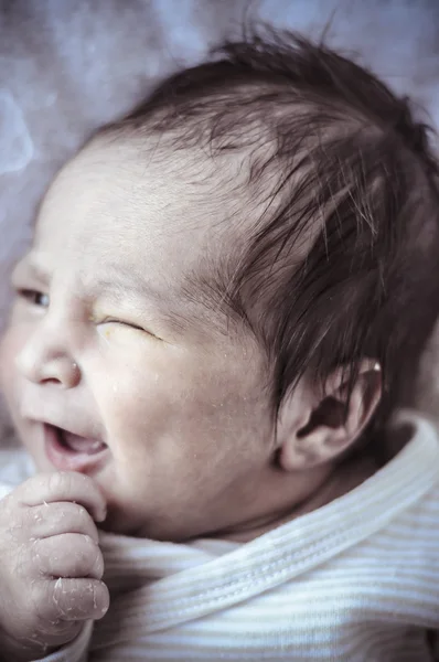 Yawn, new born baby curled up sleeping on a blanket — Stock Photo, Image