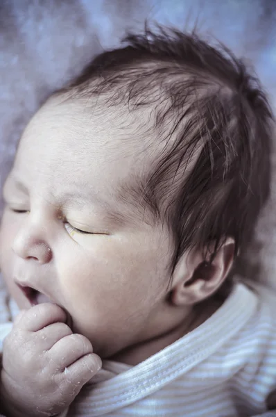 New born baby curled up sleeping on a blanket — Stock Photo, Image