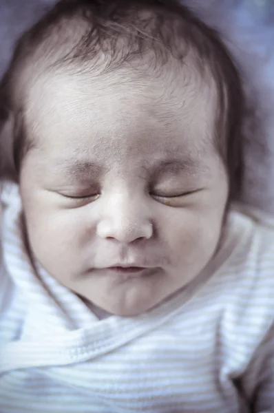 New born baby curled up sleeping on a blanket — Stock Photo, Image