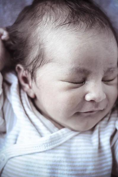 New born baby curled up sleeping on a blanket — Stock Photo, Image