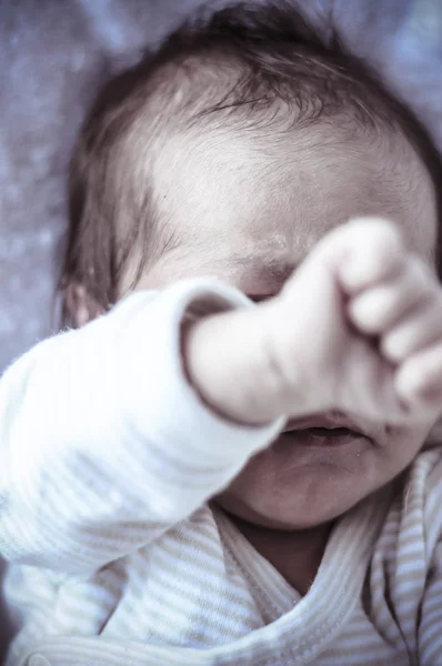 New born baby curled up sleeping on a blanket — Stock Photo, Image