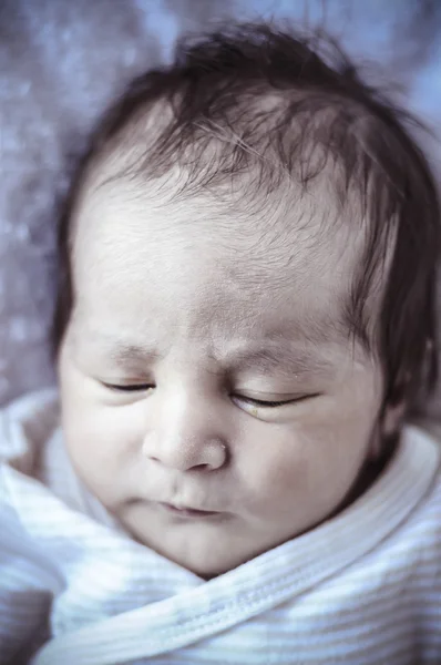 Pasgeboren baby opgerold slapen op een deken — Stockfoto