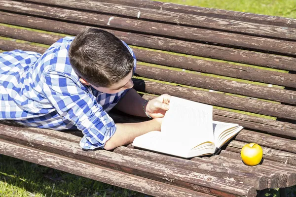 Menino lendo um livro no parque — Fotografia de Stock