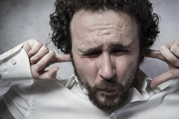 Businessman covering his ears — Stock Photo, Image