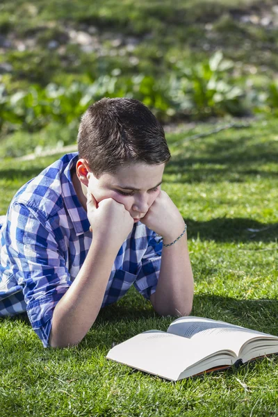 Ung pojke läser en bok — Stockfoto