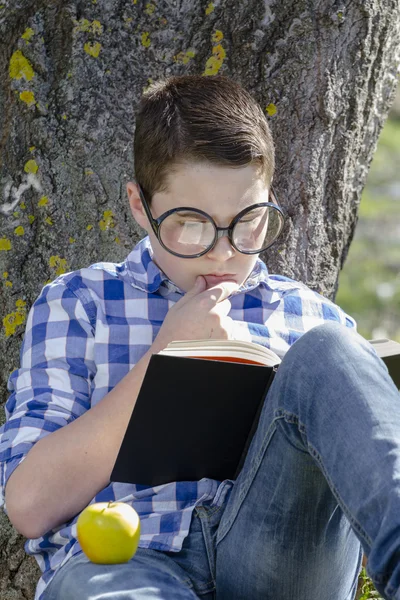 Ung pojke läser en bok — Stockfoto