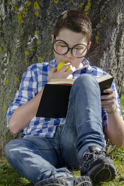 Ung pojke läser en bok — Stockfoto