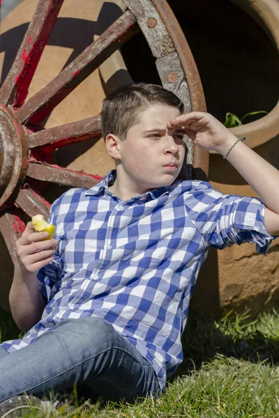 Boy lying beside a wagon wheel — Stock Photo, Image