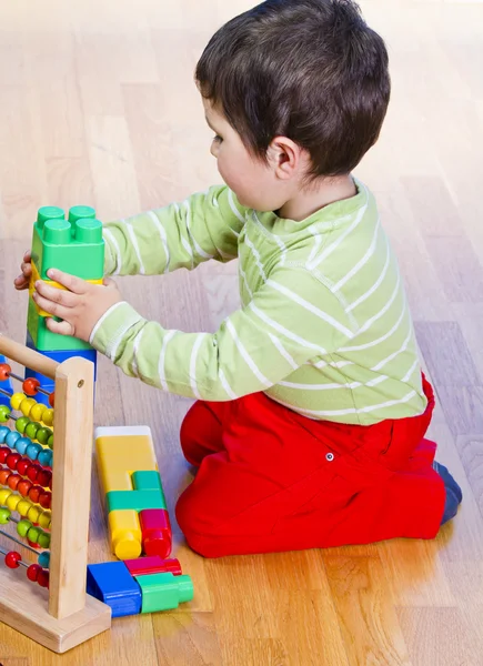 Ragazzo che gioca con blocchi di plastica — Foto Stock