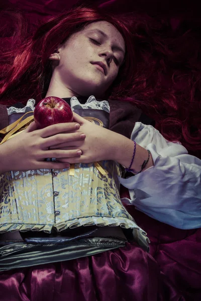 Teen with a red apple lying — Stock Photo, Image