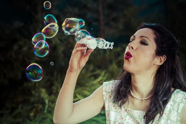Una hermosa mujer soplando burbujas — Foto de Stock