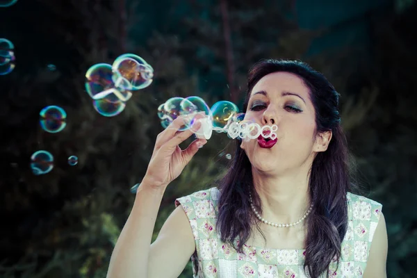 A beautiful woman blowing bubbles Stock Image