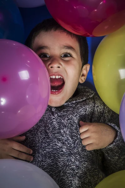 Мальчик играет с воздушными шарами — стоковое фото