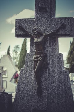 Jesus Christ on the cross in a cemetery clipart