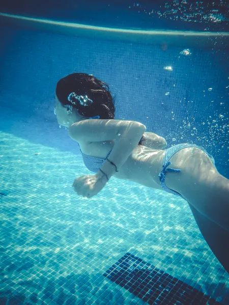 Adolescente mergulhando em uma piscina — Fotografia de Stock