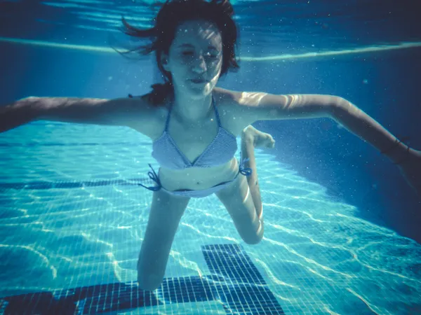 Brincando, adolescente mergulhando em uma piscina — Fotografia de Stock