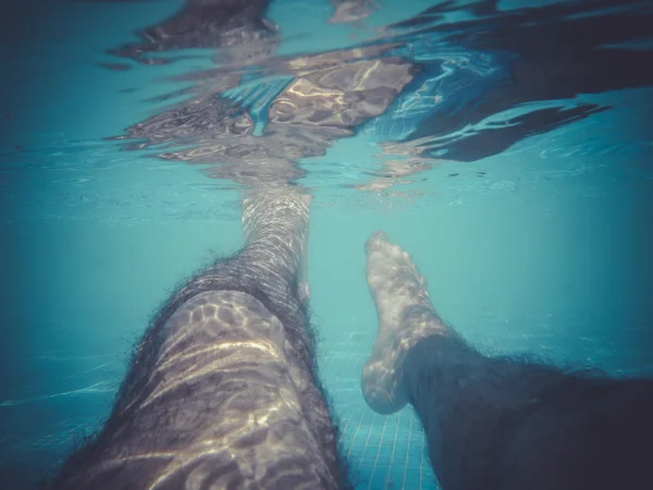 Лето, мужчина плавает под водой в бассейне — стоковое фото