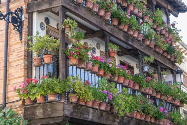 Çiçek saksıları olan eski binanın ön cephesi. Orta İspanya 'da turizm, tipik bitki dekorasyonu