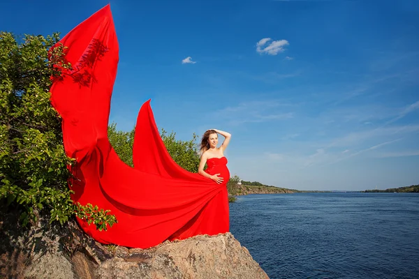 Beautiful pregnant woman in red outdoor — Stock Photo, Image