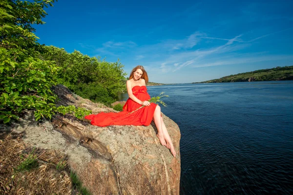 Krásná těhotná žena v červeném venkovní — Stock fotografie