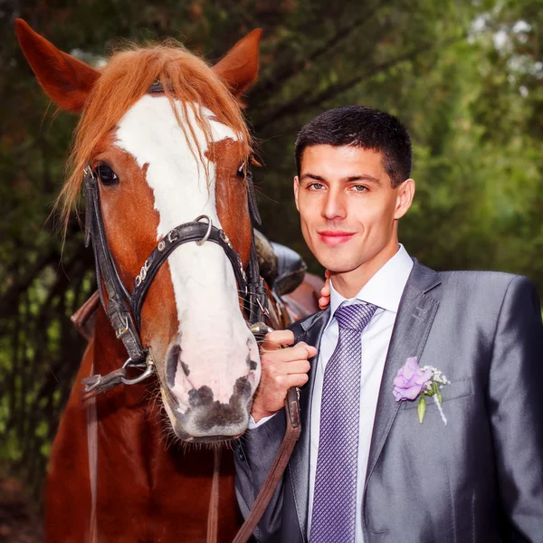 Portrait of the groom with a horse — Stock Photo, Image