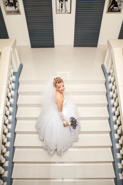 Mooie bruid met elegante witte bruiloft jurk met hand aan het hoofd — Stockfoto