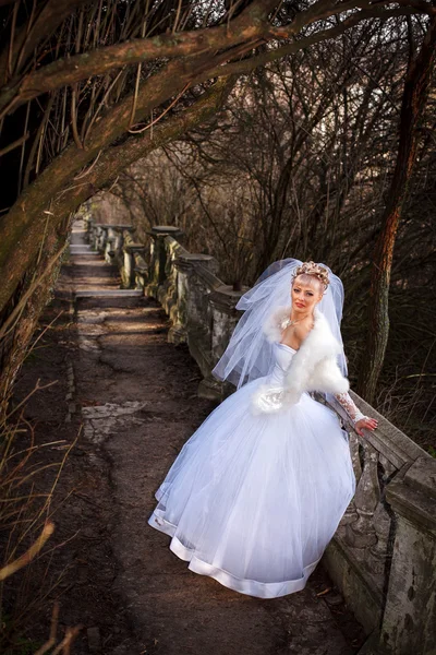 Bella sposa con elegante abito da sposa bianco con mano alla testa — Foto Stock