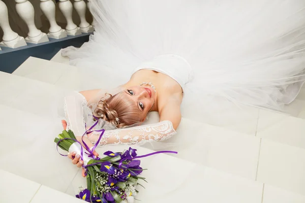 Mooie bruid met elegante witte bruiloft jurk met hand aan het hoofd — Stockfoto