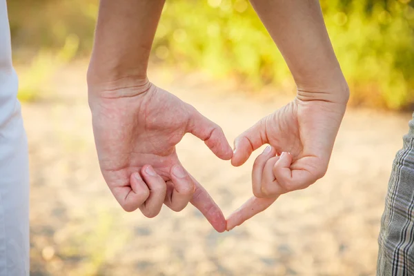 Le mani dell'uomo e della donna mostrano il gesto del cuore — Foto Stock