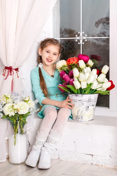 Niedliches kleines Mädchen mit Frühlingsblumen, glückliches Mädchen mit Blumenkorb. — Stockfoto