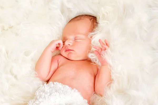 ヒツジのウールに寝ている生まれたばかりの赤ちゃん少年 — ストック写真