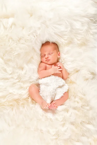 Yeni doğan bebek çocuk koyun yünü üzerinde uyuyor — Stok fotoğraf