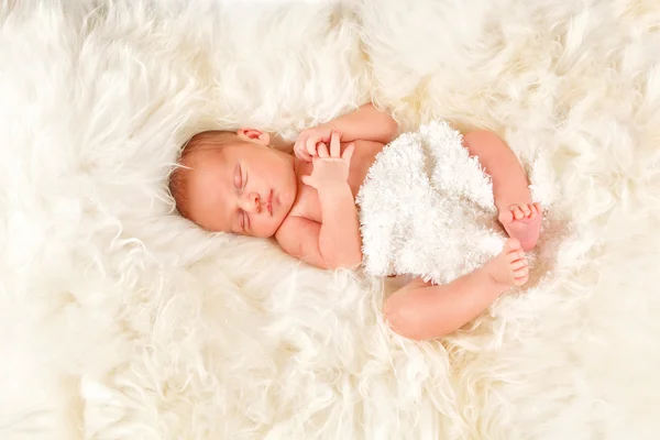 Newborn baby boy sleeping on sheep's wool — Stock Photo, Image