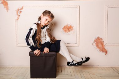 Prenses elbisesi içinde gülümseyen küçük bir kızın portresi.