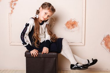 Prenses elbisesi içinde gülümseyen küçük bir kızın portresi.