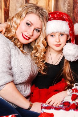 genç anne ve kızı bir şöminenin üstünde Noel tarafından