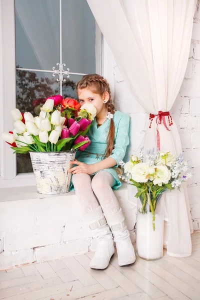 Linda niña con flores de primavera, niña feliz con cesta de flores . — Foto de Stock