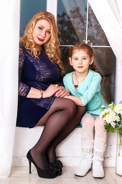 Madre e hija pequeña con flores. Primer plano de afectuosa madre e hija en casa — Foto de Stock