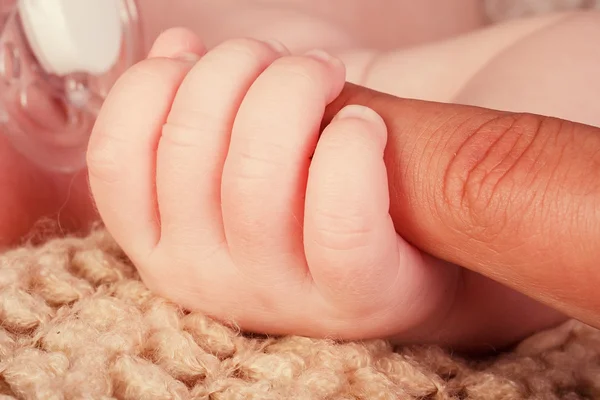 Mano de bebé sosteniendo suavemente el dedo de adulto —  Fotos de Stock