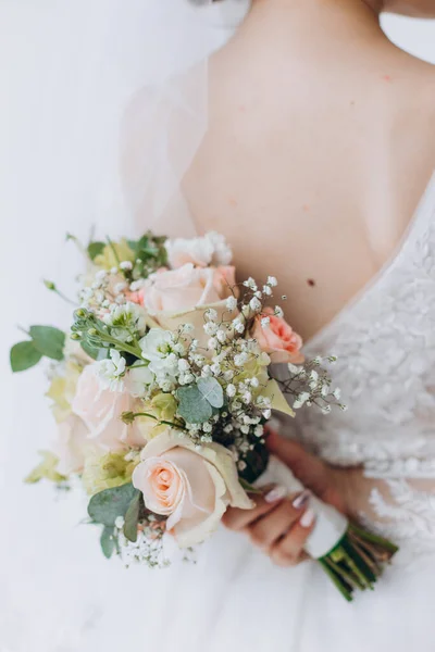 Stil, blommiga arrangemang, bröllop koncept. ung kvinna klädd i extremt vacker snöig vit klänning med puffiga kjolen håller stort gäng olika blommor sträckt med gula band. — Stockfoto