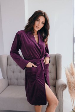 Evde banyo yaptıktan sonra bornoz ve spa havlusuyla rahatlayan sağlıklı, genç bir kadın. Güzellik, dinlenme ve vücut bakımı prosedürleri. Yüksek kalite fotoğraf