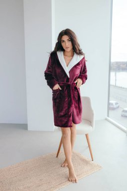 Evde banyo yaptıktan sonra bornoz ve spa havlusuyla rahatlayan sağlıklı, genç bir kadın. Güzellik, dinlenme ve vücut bakımı prosedürleri. Yüksek kalite fotoğraf