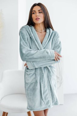 Evde banyo yaptıktan sonra bornoz ve spa havlusuyla rahatlayan sağlıklı, genç bir kadın. Güzellik, dinlenme ve vücut bakımı prosedürleri. Yüksek kalite fotoğraf