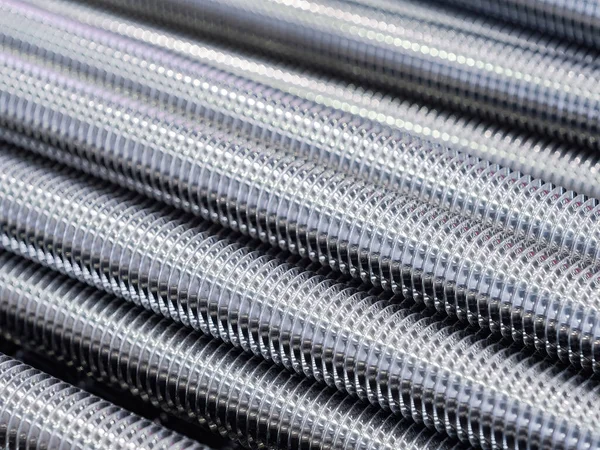 Stainless steel threaded rods abstract background.
