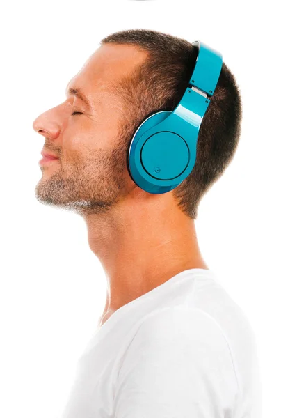 男は白い背景で隔離のヘッドフォンで音楽を聴く — ストック写真