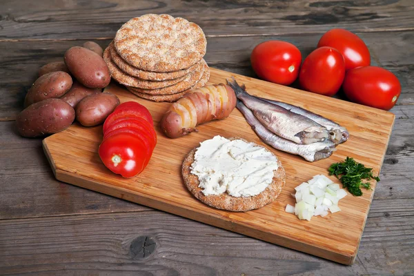 İsveçli herring ve malzemeler üzerinde kesme tahtası